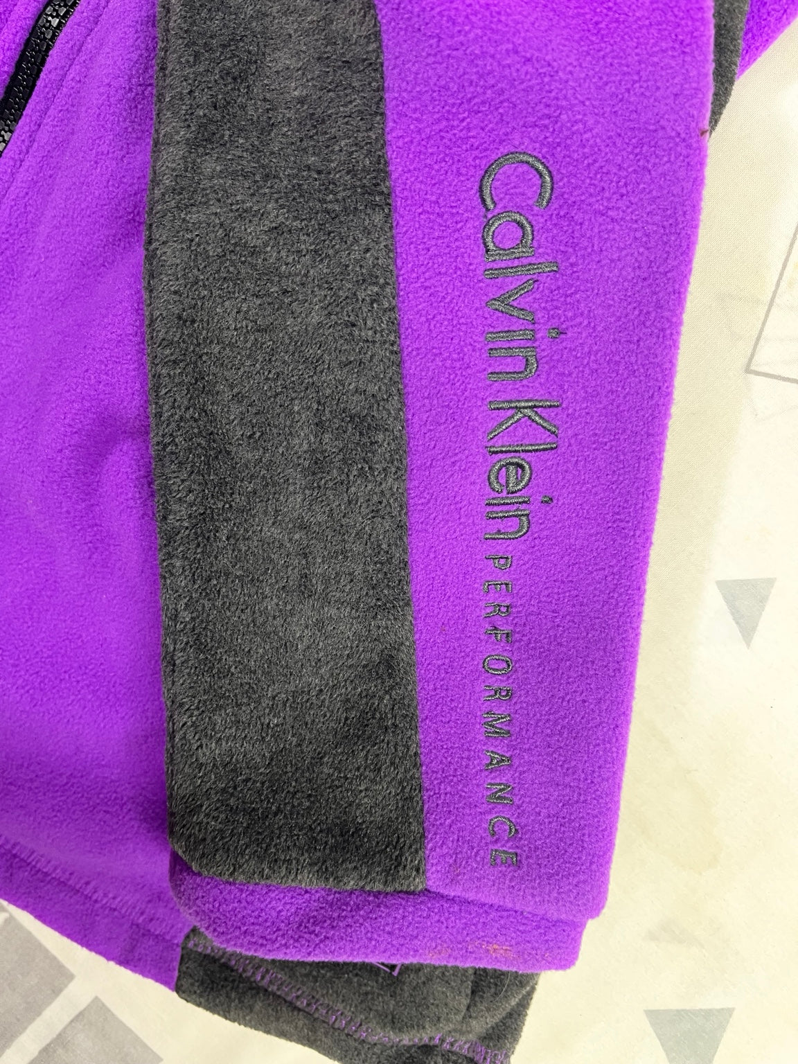 Inscripción Calvin Klein Performance en manga morada