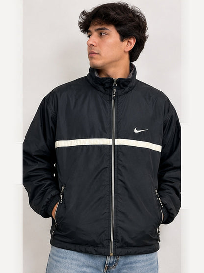 Imagen ilustrativa en modelo hombre de chaqueta Nike vintage negra (3:4). Las manchas se muestran en las fotografías reales del producto.