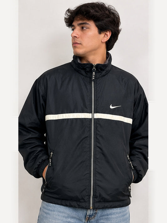 Imagen ilustrativa en modelo hombre de chaqueta Nike vintage negra (3:4). Las manchas se muestran en las fotografías reales del producto.