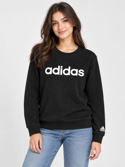 Imagen referencial con modelo mujer vistiendo polerón Adidas negro con logo blanco, formato 3:4