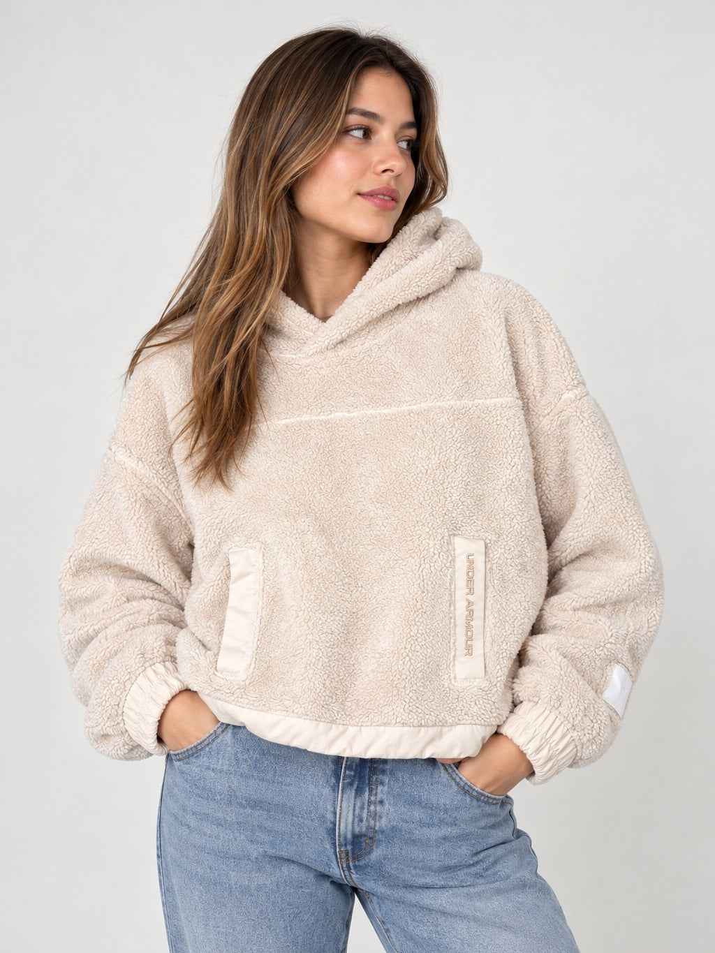Polerón Under Armour sherpa crema puesto en modelo, imagen de portada