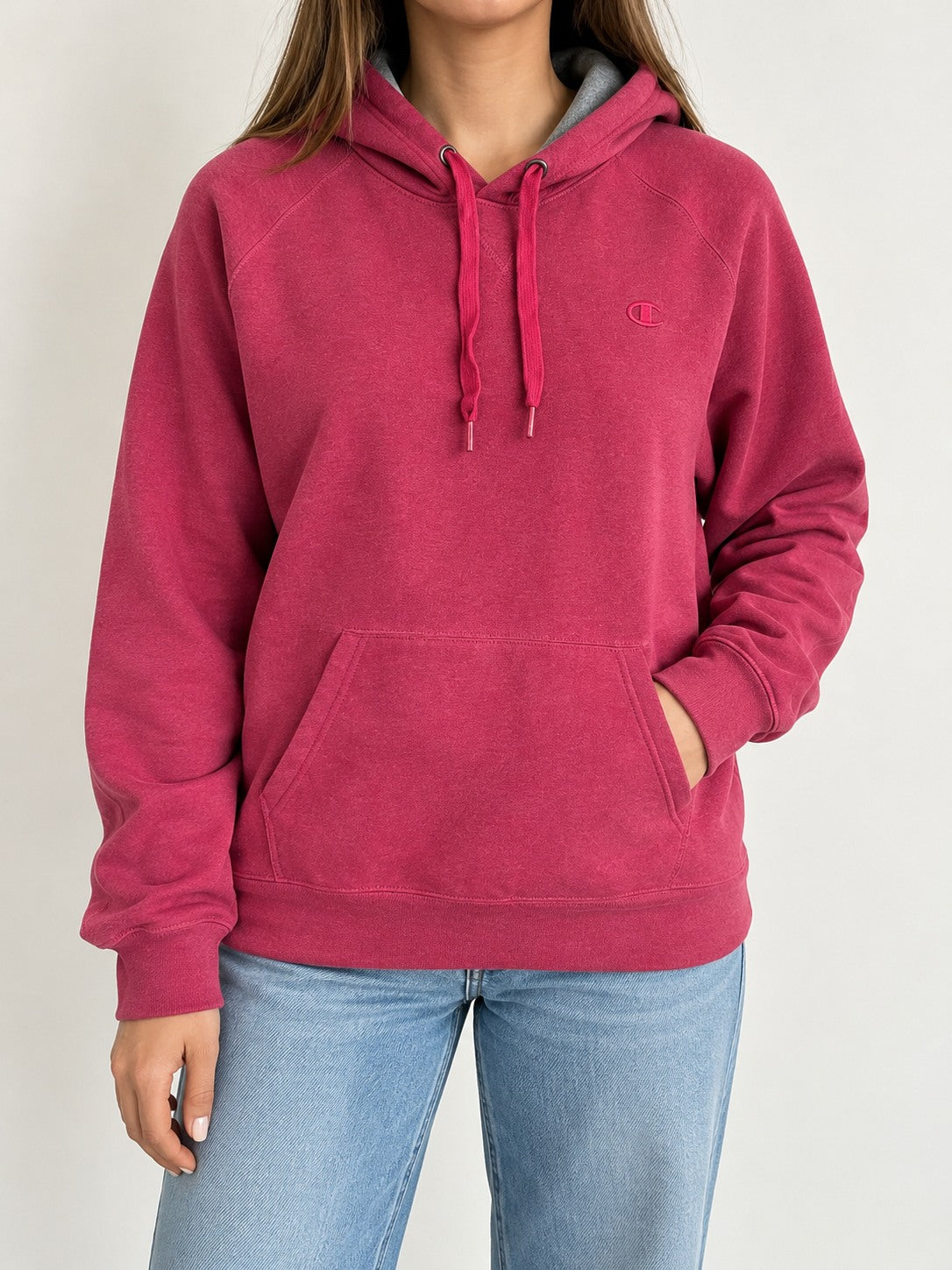 Modelo mujer, vista frontal con polerón Champion rosado (imagen referencial)